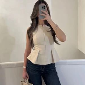 Beige ärmlös topp med struktur - Säljer min zara beige ärmlös topp med markerad midja och lätt utsvängd nederdel. Endast testat, fortfarande prislappen på säljer den för 350kr🤍Helt slutsåld på hemsidan:)