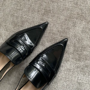 Svarta loafers med klack och spetsig tå - Säljer ett par svarta loafers med klack och spetsig tå. Skorna har öppen häl och en stilren design i glansigt material. Perfekta för dig som vill ha en trendig och elegant look.