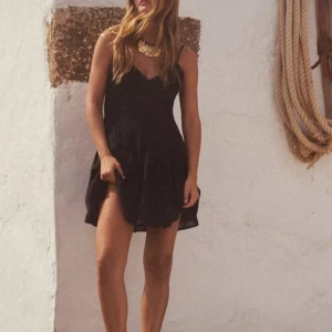 Svart kortklänning med spetsdetaljer - Säljer en svart kortklänning med smala axelband och v-ringad hals. Klänningen har fina spetsdetaljer upptill och en lätt utsvängd kjol. Perfekt för dig som gillar en enkel men stilren look. Helt oanvänd 