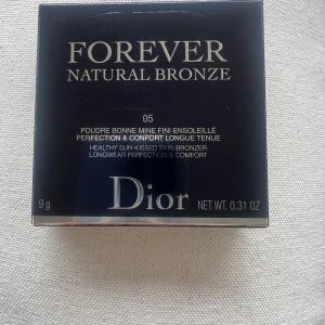 Dior Forever Natural Bronze 05 Warm Bronze - Lyxig bronzer från Dior i nyansen 05 Warm Bronze. Kommer i en elegant beige rund dosa med quiltat mönster och silverfärgad CD-logga. Ger en solkysst look och långvarig komfort. Innehåller 9g puder.