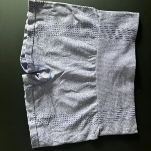 Lila sömlösa träningstights shorts - Snygga lila shorts med hög midja och sömlös design. Perfekta för träning eller gymmet, med ventilerande detaljer på sidorna och bred resår i midjan för extra komfort. Shortsen är i en fin lila färg men det va svårt att få på bild! 