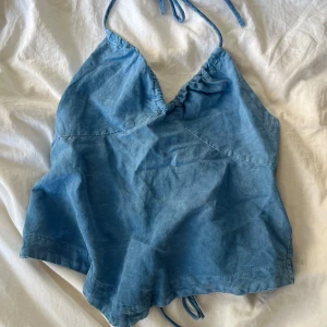 Blå halterneck topp från ZARA - Säljer en ljusblå halterneck topp från ZARA med knyt i nacken och öppen rygg. Toppen har en lätt utsvängd passform och är tillverkad i ett mjukt bomullsliknande material. Bara använt en gång, säljer eftersom den är för stor🩵🩵