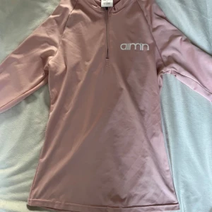 Rosa långärmad träningströja från Aim'n - Säljer en ljusrosa långärmad träningströja från Aim'n med halv dragkedja framtill och logga på bröstet. Tröjan är i stretchigt material och har en tight passform, perfekt för träning eller sportiga aktiviteter.Zippen eller dragkedjan är lite sönder, den krånglar ibland! Köptes för 600 kr men säljs för så billigt pga dragkedjan som krånglar IBLAND! 💞Skriv privat för fler bilder eller andra frågor 