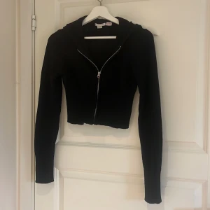 Svart croppad hoodie med dragkedja - Används inte. Jätte skönt material. Är i barn storlek 170 men passar xs och s