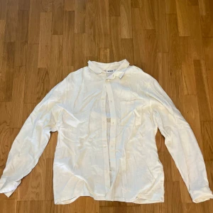 Vit linneskjorta från Weekday - Säljer en stilren vit skjorta från Weekday i linne. Skjortan har klassisk krage, knäppning framtill och långa ärmar. Perfekt för en clean och avslappnad look.