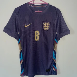 England Fotbollströja EM 2024 - Dags för rensning igen! Säljer denna helt oanvända fotbollströjan. Beställde den i samband med EM 2024 men då den var för liten användes den aldrig och har bara hängt i garderoben. För mer frågor eller bilder skriv! Priset kan diskuteras vid snabb och smidig affär.