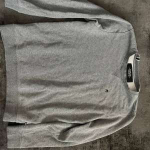 Grå sweatshirt från Selected Homme - En stilren grå sweatshirt från Selected Homme med rund halsringning och diskret logga på bröstet. Tröjan har långa ärmar och är tillverkad i mjuk bomullsmix, perfekt för en avslappnad look.