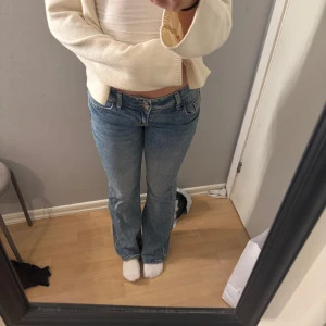 Blå bootcut jeans med broderad detalj - Snygga blå bootcut jeans med låg midja och snygga detaljer på backfickan. Såå snygga och endast testade 