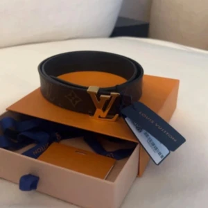 Louis Vuitton monogram bälte med guldfärgat spänne - LV initales 30mm reversible. Storlek 75cm. Två olika sidor som kan användas (ena är svart o andra är LV logga).  Lite repor på Lv loggan (se bild) men inget som märks irl. Nypris idag  5450  Kvitto och tillbehör medföljer.