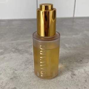 Ida Warg Tanning Drops - Tanning drops från Ida Warg i en genomskinlig glasflaska med guldig pump. 100% vegansk och parfymfri formula som blandas med din vanliga ansiktskräm för en solkysst look. Perfekt för att bygga upp en naturlig bränna.