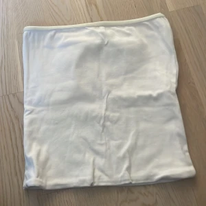 Vit tubtopp från Bik Bok - Säljer en enkel och stilren vit tubtopp från Bik Bok i storlek S. Toppen är ärmlös och har en mjuk, stretchig känsla som passar perfekt till sommaren. Perfekt att matcha med jeans eller kjol för en fräsch look.