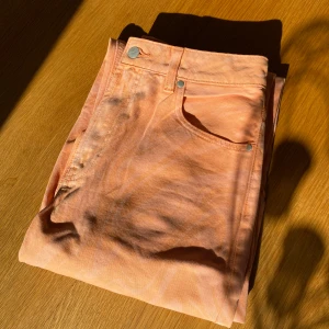 Persikofärgade jeansbyxor - Säljer ett par persikofärgade jeansbyxor med  mönster. Passar small/medium. Har en liten reva i midjan se sista bild. Rensar ur min garderob från en hel del oanvända kläder🌼 Om du ser något mer i min profil som du gillar så skickar jag med det till dig också!😊 Fler kläder kommer! 