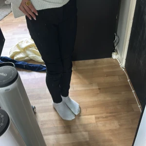 Svarta skinny jeans - Säljer ett par svarta skinny jeans med normal passform i midjan. Byxorna är stilrena och passar perfekt till vardags. De har klassisk femficksdesign och är gjorda i ett stretchigt material för extra komfort.