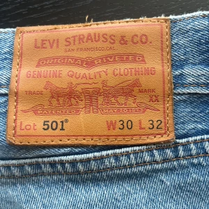 Levi's 501 ljusblå jeans W30 L32 - Klassiska Levi's 501 jeans i ljusblå denim. Rak passform med knappgylf och 4 fickor. Tidlös modell med normal midja och ikonisk läderpatch bak. Perfekta för en avslappnad stil.