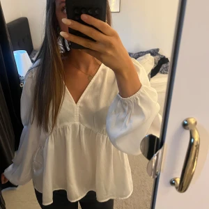 Vit v-ringad blus med volanger❤️ - Säljer en luftig vit blus med v-ringning och långa puffiga ärmar. Blusen har en volang nedtill och är i siden liknande material🤗🤗