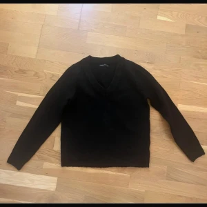 Svart stickad tröja - En svart stickad tröja med långa ärmar. Enkel och stilren modell som passar perfekt till jeans eller kjol. Tröjan har en normal passform och är mjuk och skön att bära.