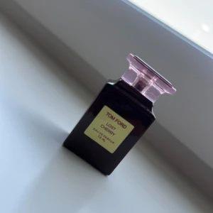 Tom Ford Lost Cherry EdP 25 ml - Tom Ford Lost Cherry Eau de Parfum i 25 ml flaska. Flaskan är mörkröd med en fyrkantig form och har ett transparent rosa lock med Tom Ford-logga. Lyxig och ikonisk design som sticker ut på parfymhyllan.