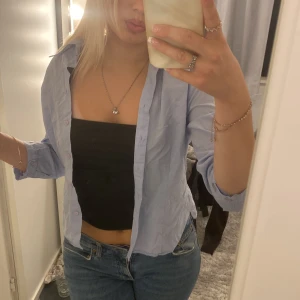 Ljusblå skjorta med trekvartsärm - Säljer en ljusblå skjorta med trekvartsärmar och knappar framtill. 