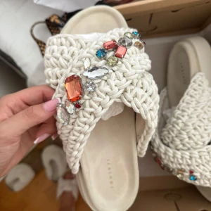 Vita sandaler med pärlor från Inuikii - Helt nya Inuikii tofflor, aldrig använda endast provade i storlek 40. Säljer pga att de är för stora för mig och är utanför ångerrätten. Modellen är slutsåld överrallt.