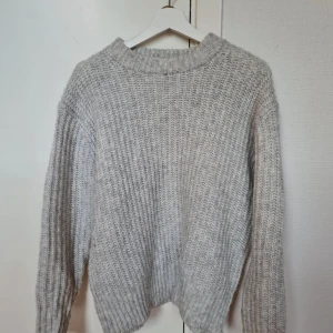 Ljusgrå stickad tröja - Supermysig ljusgrå stickad tröja från 157 i storlek XS. Tröjan har grov ribbstickning, rund hals och långa ärmar med breda muddar. Perfekt för kyliga dagar och enkel att matcha med jeans eller kjol. Snygg och enkel design som funkar till allt.