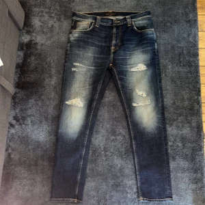 Nudie jenas - Nudie jeans med slitningar storlek W31 L28, Jenssen är i väldigt bra skick.