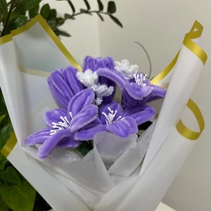 Lila Blombukett💜 - Bilderna visar en bukett med lila och vita blommor gjorda av piprensare, inslagna i vitt papper med guldkant. Konstgjorda blommor som kan användas som dekoration eller present.