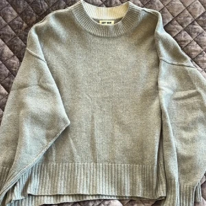 Grå stickad tröja från Soft Goat - Snygg grå stickad tröja från Soft Goat med rund hals och ribbade muddar vid ärmslut och nederkant. Tröjan har en loose passform och är perfekt för kyliga dagar. Enkel och stilren design som funkar till många olika outfits.
