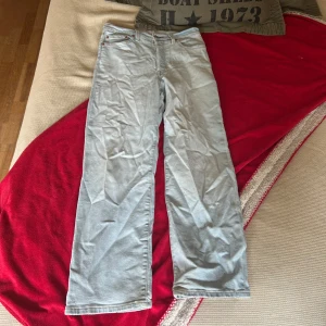 Levi's Ribcage Straight Ankle jeans ljusblå - Säljer ett par Levi's Ribcage Straight Ankle jeans i ljusblå denim. De har hög midja, raka ben och klassiska Levi's-detaljer som läderpatch och röda etiketten bak. Perfekta för dig som gillar en clean och tidlös look. Jag är 163 och dessa jeans är perfekt i längden. Inte använt så många gånger eftersom jag inte kan ha dom längre. 