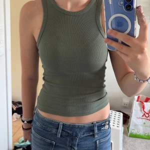 Olivgrön ribbad linnetopp Bik Bok - Snygg olivgrön ribbad linnetopp från Bik Bok i storlek S. Modellen är medellång och ärmlös med rund halsringning, perfekt till jeans eller shorts. Skriv om ni har frågor💕