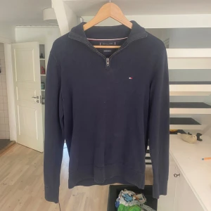 Marinblå half zip tröja Tommy Hilfiger - Snygg marinblå tröja från Tommy Hilfiger med half zip. Perfekt för ge dig en lite mer classy look och få dig några blickar. Ny pris 1200 mitt pris 199