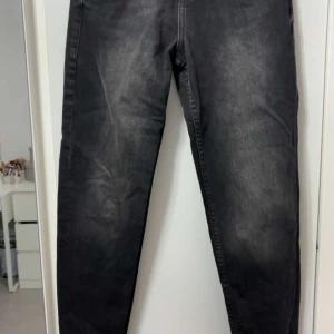 Svarta jeans från Zara, storlek 32 - Snygga svarta jeans från Zara i storlek 32. Jeansen har en klassisk femficksmodell, raka ben och hög midja. Materialet är denim i bomull med en lätt tvättad look som ger en cool vibe. Perfekta till sneakers eller boots.