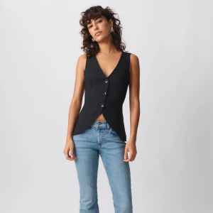 Svart figursydd väst med knappar - Snygg svart väst med figurnära passform och djup v-ringning. Västen har tre knappar framtill och en stilren, något spetsig nederkant. Perfekt att styla över en t-shirt eller direkt mot huden för en trendig look. Den är använd en gång därav ett väldigt bra skick🥰