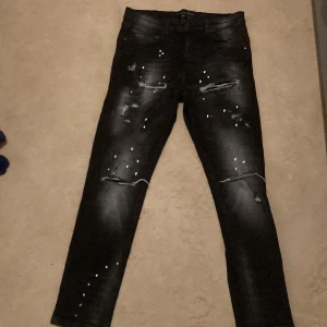 SUPPLY&DEMAND - Säljer ett supply & demand med coola slitningar och vita färgstänk på framsidan. Jeansen har en tight passform och är tillverkade i stretchigt denimtyg. Perfekta för dig som gillar en edgy och trendig stil.