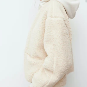 Beige teddyjacka med knappar - Supermjuk och fluffig teddyjacka i beige från H&M. Jackan har rund hals, stora fickor framtill och stängs med knappar. Perfekt oversized passform och långa ärmar, passar till alla dina outfits när det är kyligt ute.