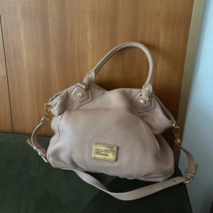 Beige handväska från Marc by Marc Jacobs - Snygg beige axelväska i mjukt skinn från Marc by Marc Jacobs. Små slitningar på handtagen
