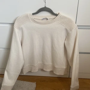 Vit stickad tröja från Zara - Superfin vit stickad tröja från Zara med ribbade detaljer vid hals, axlar, ärmslut och nederkant. Tröjan har en klassisk rund halsringning och lång ärm, perfekt för lager-på-lager och chill vibes.