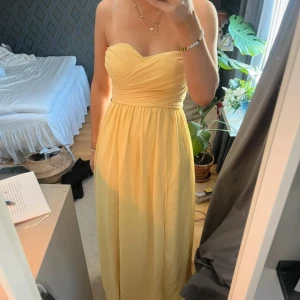 Gul långklänning från LuLu's - Kan sänka pris vid snabb affär! Drömklänning från det populära märket Lulus - perfekt till bal, student eller sommarbröllop! Ljusgul i en varm nyans. Köptes till ett speciellt tillfälle som aldrig blev av - därfor i helt nytt skick! -Slits pa högersidan -Dragkedja i ryggen.