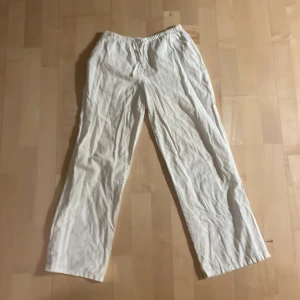 Vita linnebyxor från Gina Tricot - Luftiga vita linnebyxor från Gina Tricot med rak passform och elastisk midja med snörning. 