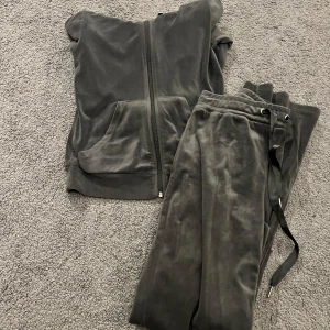 Mörkgrå mjukissätt från Gina Tricot - Säljer ett mörkgrått sätt från Gina Tricot, storlek XXS och XS. Tröjan har huva med snörning, dragkedja framtill och en stor ficka på magen. Perfekt för chill dagar och har långa ärmar. Snygg och skön att bära när du vill vara extra comfy.