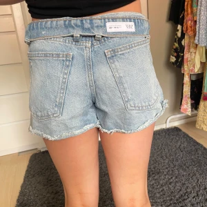 Ljusblå jeansshorts från Zara - Snygga ljusblå jeansshorts från Zara med råa, fransiga kanter och slitna detaljer. Klassisk femficksmodell med normal passform och midwaist. Perfekta för sommaren och ger en avslappnad vibe till din outfit.