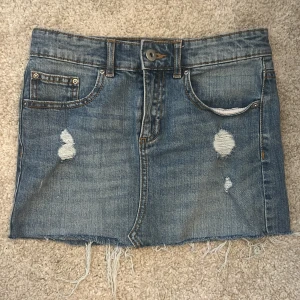 Blå jeanskjol med slitningar  - Snygg blå jeanskjol från 157 med hål, köpte på Karlaplan men har aldrig använt pga den är för liten 💗