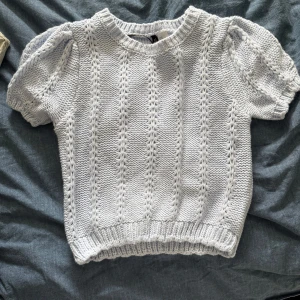 Ljusblå stickad kortärmad tröja Hm - Supersöt ljusblå stickad tröja från HM med korta puffärmar och ribbade muddar. Använd en gång 