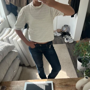 Vit blus med puffärm och spetsdetaljer - Säljer en söt vit blus med puffärmar och broderade spetsdetaljer. Blusen har en hög krage med volang och korta ärmar med rynk vid axlarna. Perfekt för dig som gillar romantisk och feminin stil.