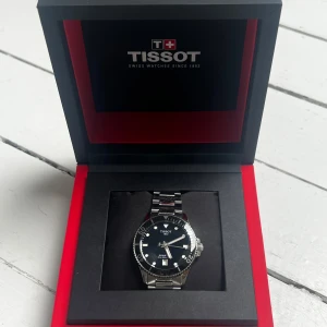 Tissot Seastar 1000 Quartz - Tissot Seastar 1000 – Elegant och sportig dykarklocka med svart urtavla, 300 m vattentålighet och automatverk. Perfekt för både vardag och äventyr. Har kvitto!                       40mm STAINLESS STEEL SAPPHIRE CRYSTAL WATER RESISTENT  30bar (300m/1000ft)