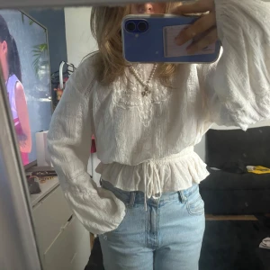 Vit blus med spets och snörning - Säljer en söt vit blus med spetsdetaljer vid halsen och snörning i midjan. Blusen är från mango! Nypris runt 800kr och jag minns rätt. 