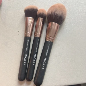 3 sminkborstar från Hickap - Säljer tre snygga sminkborstar från Hickap: Angled Kabuki, Multi Highlight och Powder Deluxe. Borstarna har svarta handtag, roséguldfärgade detaljer och mjuka syntetiska borst i beige och brunt. Perfekta för contour, highlight och puder.