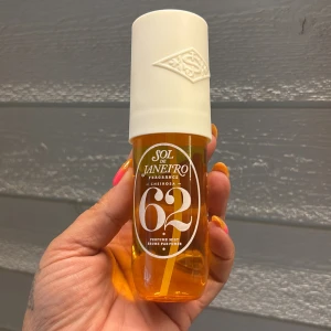 Sol de Janeiro Cheirosa 62 Parfymmist - Sol de Janeiro Cheirosa 62 Perfume Mist i en snygg genomskinlig orange plastflaska med vit kork. Doften är ikonisk och tropisk, perfekt för dig som gillar varma, söta toner. Flaskan har en modern design och är lätt att ta med i väskan.