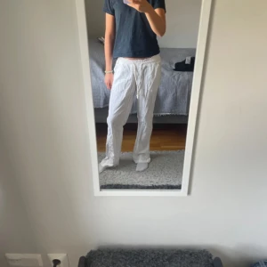 Vita linnebyxor från Roxy med snörning - Säljer ett par vita linnebyxor från Roxy med avslappnad passform. Byxorna har resår och snörning i midjan, raka ben och praktiska fickor fram. Perfekta för varma dagar och chill vibes.