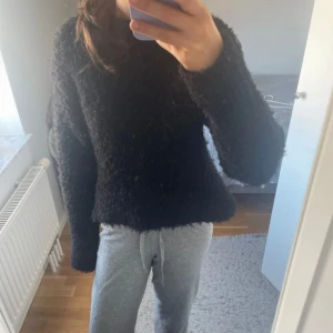 Svart fluffig stickad tröja H&M XS - Mysig svart stickad tröja från H&M i storlek XS. Tröjan har en fluffig textur, rund halsringning och långa ärmar. Perfekt för kyliga dagar när du vill ha något både bekvämt och snyggt.