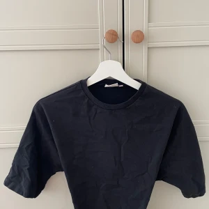 Knyt topp från Nelly - Svart croppad topp från Nelly med rund halsringning och korta ärmar. Toppen är o xxs men kan passa nån som är i xs/s eftersom man kan justera bandet, det är en stilren look som passar perfekt till jeans eller kjol. Snygg och basic för dig som gillar minimalistisk stil.